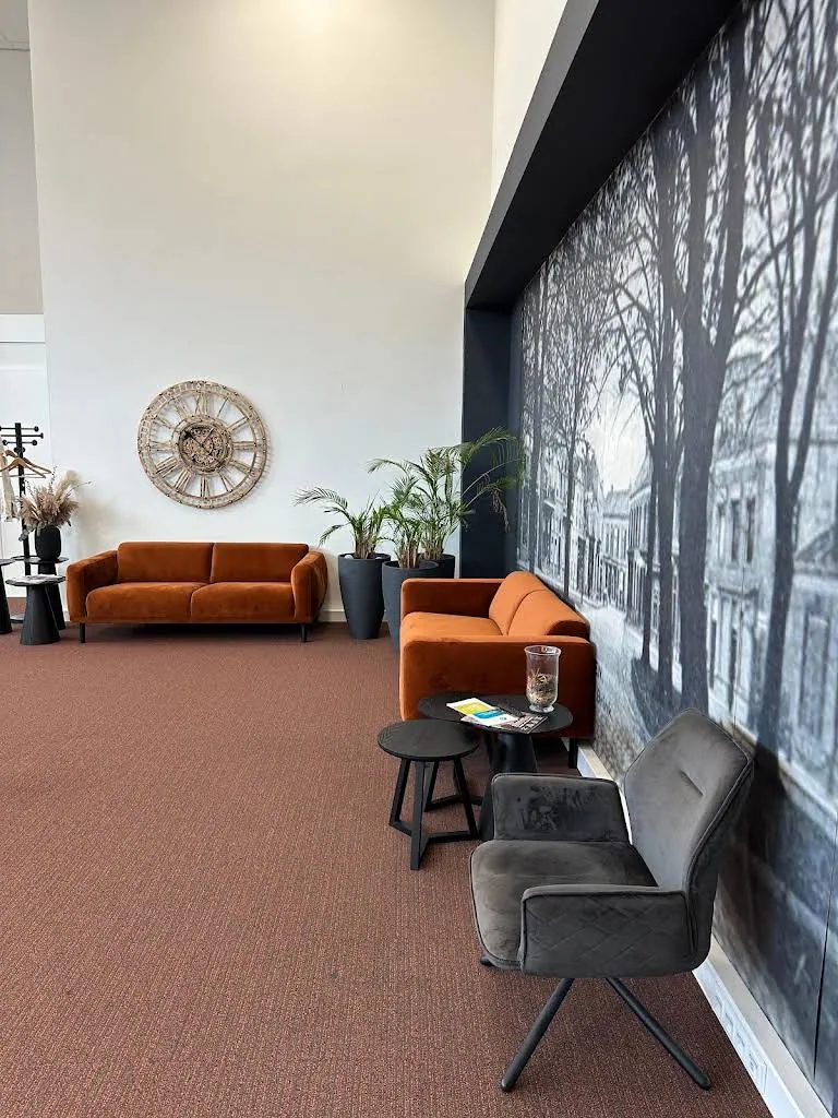 De ontvangstruimte van Atlas in Assen met oranje banken, uit ons Google-bedrijfsprofiel